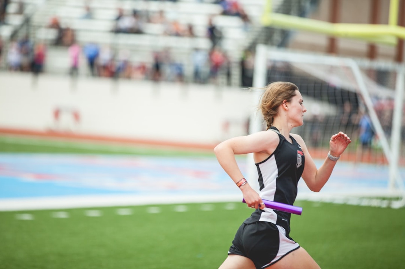 A runner on a track carrying a baton